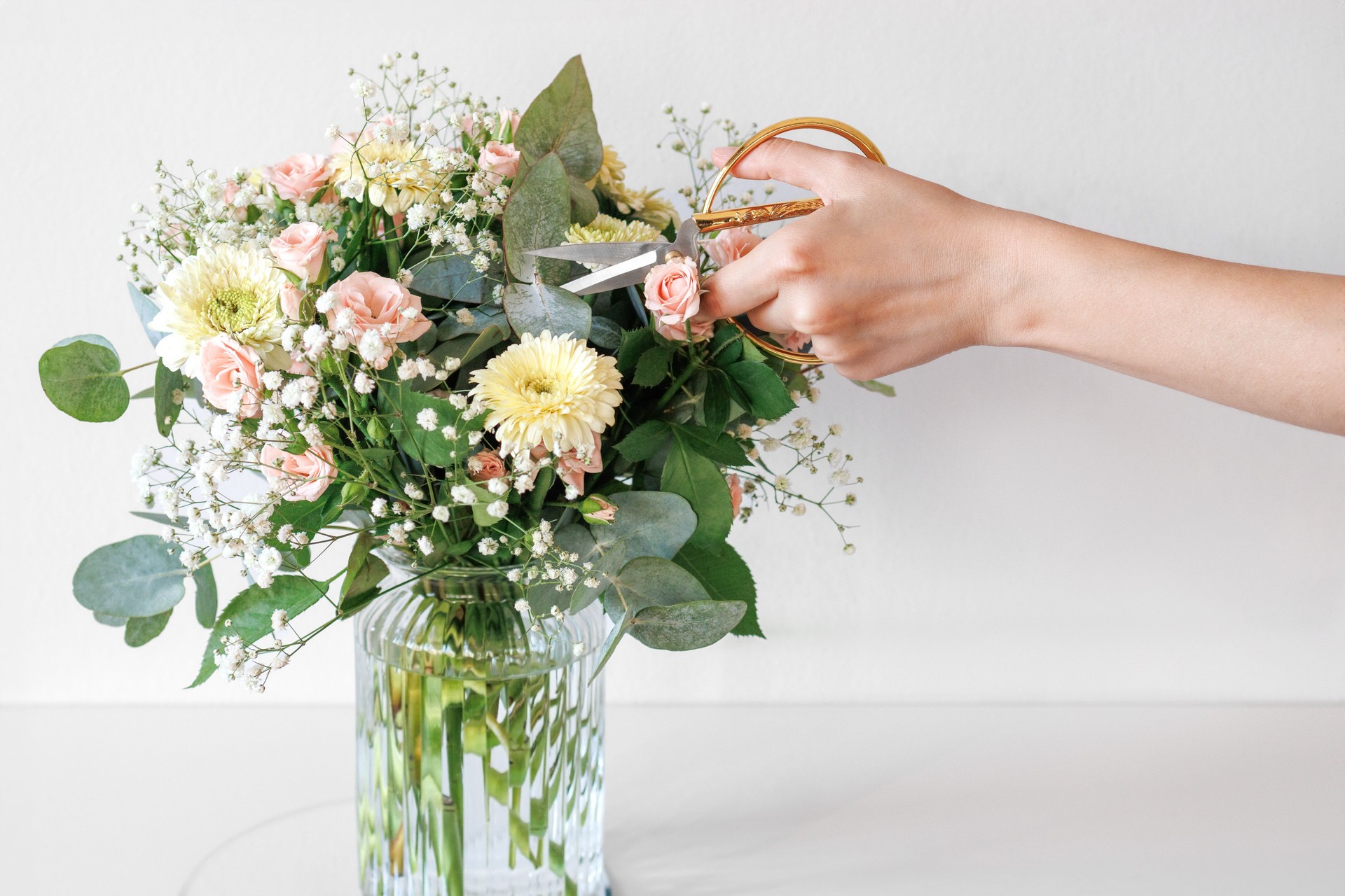 Florist Is Making A Flower Arrangement Using Pastel Colored Roses And Gerberas. Florist Arranging Flowers Bouquet Using Scissors In A Glass Vase. Flowers Care Concept.