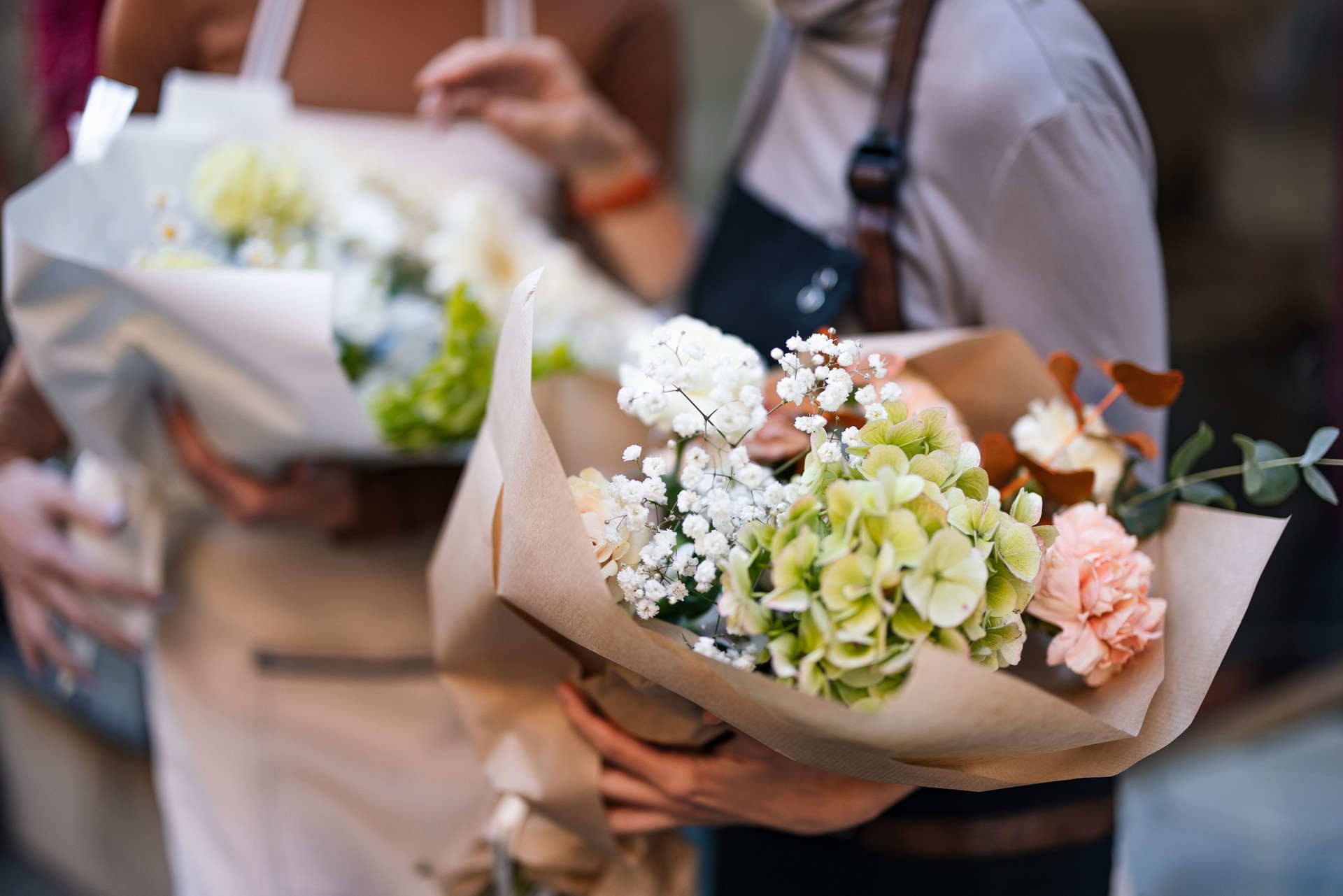 Two Florists Holding Beautifully Arranged Mixed Bouquets Outdoors